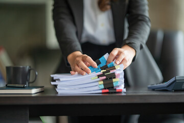 Close-up hand of Asian businesswoman arranging documents on her desk.