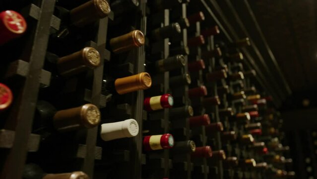 Close up panning on wine bottles in dark wine cellar in luxury home