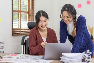 Shot of two Young Asian businesswoman working together on digital tablet. Creative Asian female executives meeting in an office using tablet pc and smiling.
