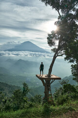 person on a mountain with a view of a volcano