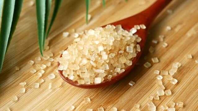 crystal brown sugar brown on a wooden spoon on table 