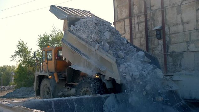 The dump truck dumps the stone into the bunker. Close-up