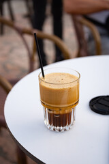 A glass of frappe mochaccino macchiato on a bar table