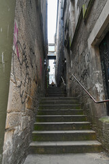 Kleine, enge und dunkle Gasse mit Treppenstufen führt durch die Häuserschluchten von Edinburgh,...