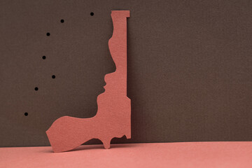 paper cut gun silhouette with human face texture. STOP GUN VIOLENCE and killings concept, space for...