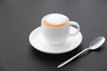 Cappuccino White cup on a black background. Coffee on a black background.