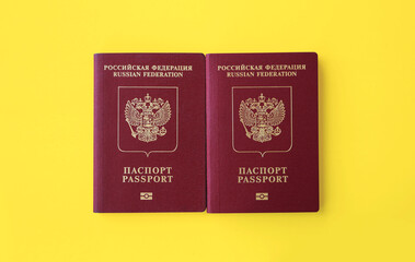 Two Russian international passports on a bright yellow background. The concept of a vacation for two abroad.