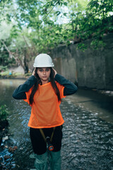 Young beautiful woman digger walks along the rain collector