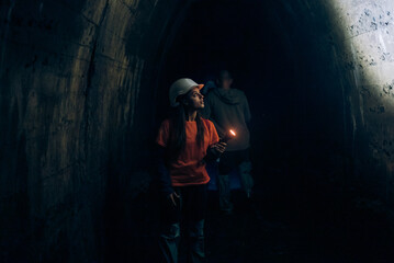 Fototapeta na wymiar Female digger with flashlight explores the tunnel