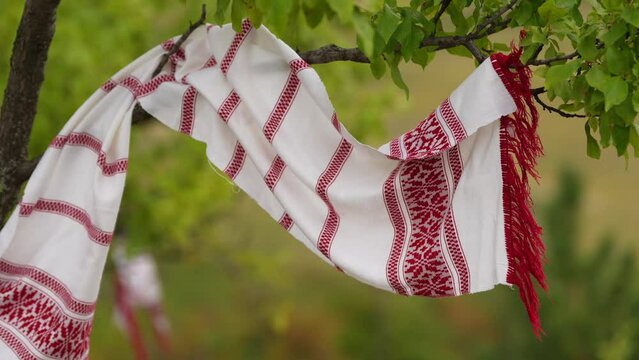 4k video with a traditional Romanian scarf or vintage kitchen towel with red and white models part of the Romania culture and traditions. Concept film for Romania, mixing nature and clothing. 