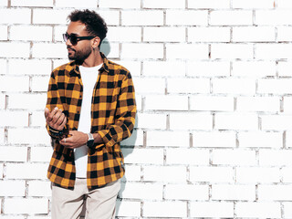 Handsome confident hipster model. Sexy unshaven man dressed in yellow  summer shirt and jeans...