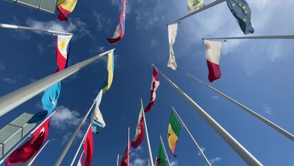 Flags of the World waving in the wind on a background blue sky and white clouds. flags of many countries.  for political, international trade, relationship concepts