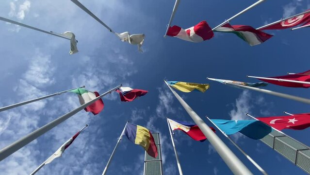 Flags of the World waving in the wind on a background blue sky and white clouds. flags of many countries.  for political, international trade, relationship concepts