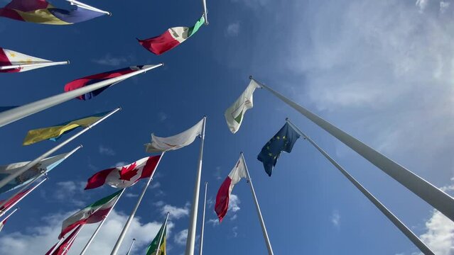 Flags of the World waving in the wind on a background blue sky and white clouds. flags of many countries.  for political, international trade, relationship concepts