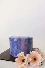 Blue and Pink Glazed Mirror Cake with Pink Flower in a White Isolated Background