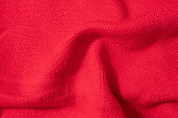 Red wool knitted textured background close up. Handmade knitted fabric red wool background texture