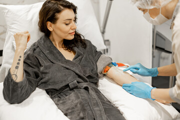 Nurse makes an injection into a vein taking blood for tests or washing blood with a dropper for a...