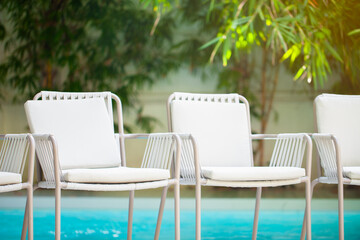 White chairs around outdoor with swimming pool background in restaurant hotel for vacation, patry, relex, holiday.