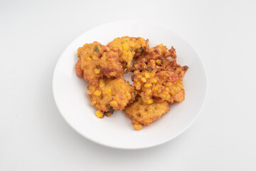 close up of fried corn fritter or in Indonesia called Perkedel Jagung or Bakwan Jagung with shrimp inside isolated on white background