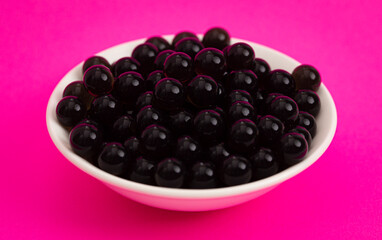 Bowl of Popping Boba Pearls on a Bright Pink Background