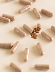 Opened Medical capsules on light beige close up. Taking dietary supplements