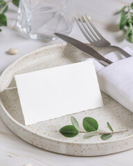 Table setting with folded card decorated with eucalyptus branches close up, Wedding mockup