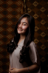 Fototapeta premium Beauty portrait of happy Asian woman face with natural skin on Indonesian Batik background.