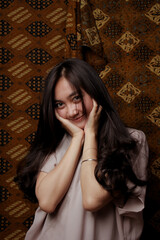 Fototapeta premium Beauty portrait of happy Asian woman face with natural skin on Indonesian Batik background.