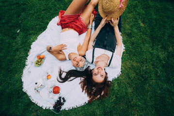 Top view, two young women lying in the park