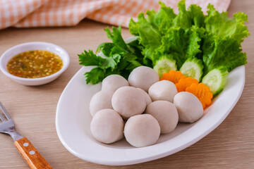 Boiled fish balls and vegetable on white plate.