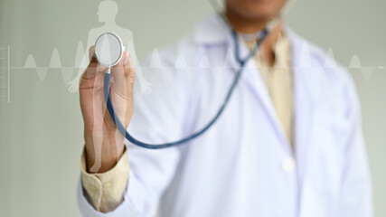 Doctor using stethoscope to check body and heart, human body hologram and electrocardiogram, medical concept.