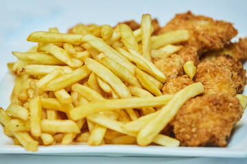 French fries and nuggets in a plate on the table.