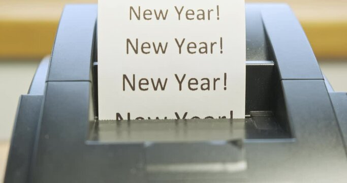Receipt printer prints text: New Year. Close-up, front view. Concept of holidays, new year, christmas, new stage, promotions, sales in stores. Tear off the check