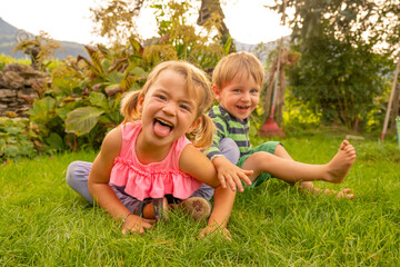 Little girl and boy having fun in the yard