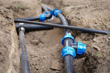 Black plastic pipes for irrigation in country