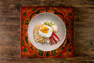 Teriyaki chicken donburi with fried egg, onion, red pepper and other vegetables. Typical Japanese dish.