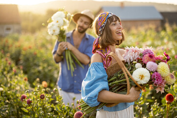 Portrait of a beautiful and cheerful woman as a farmer or gardener holding basket full of freshly...