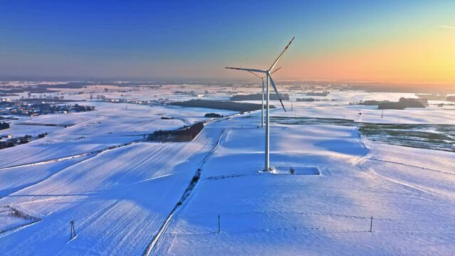 Alternative energy in winter. Wind turbine on winter snowy field.