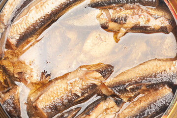 canned smoked sprats in oil texture background close-up