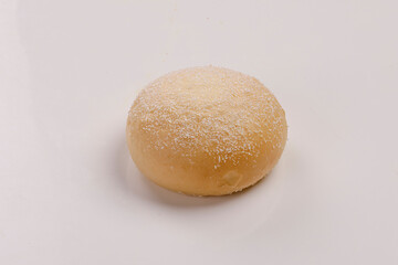 Top view of fresh baked wheat bun isolated on white