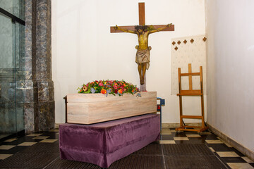 coffin with flowers on it in church with Jezus Christ against the wall waiting to be transported for the service © fotografiemahieu