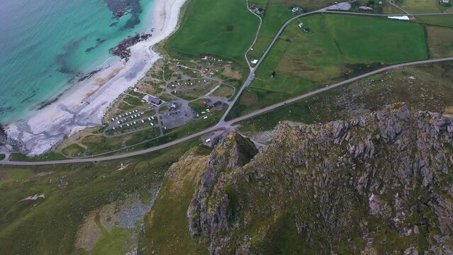 Dramatic aerial view of the Norwegian coastline with mountains and white sand beach in the Lofoten islands