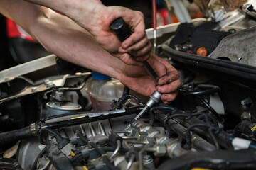 Obraz premium Close up of car mechanic hands doing car service and maintenance. Mechanics workshop.