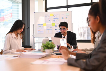 Group of professional businesspeople sitting in conference room and discuss financial paperwork