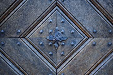 Detail of an old wooden door with traditional metal door knob.