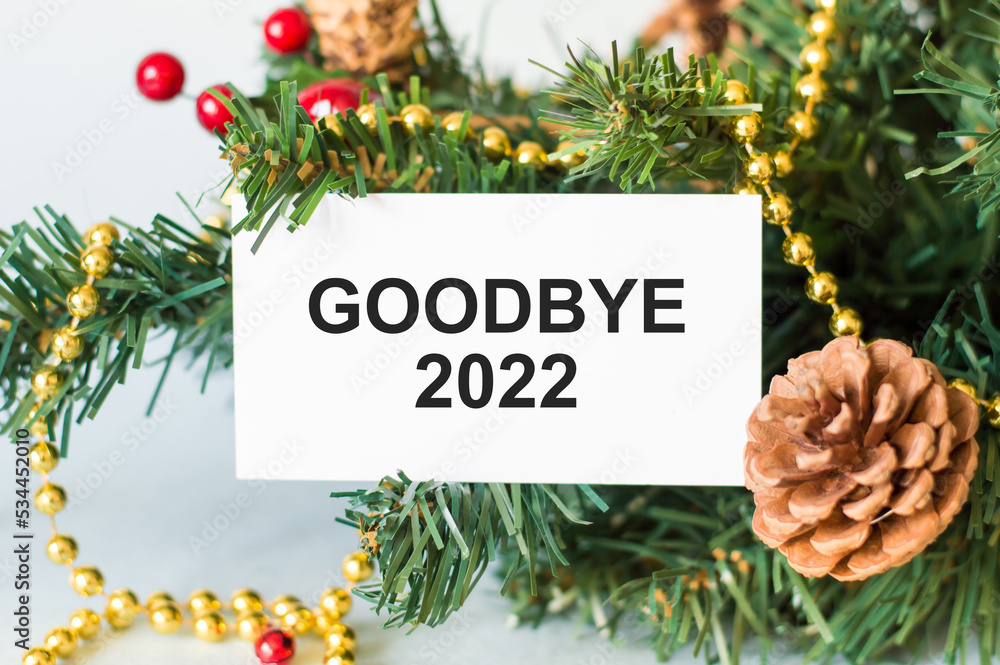 Poster goodbye 2022 text on a card against the background of a spruce branch