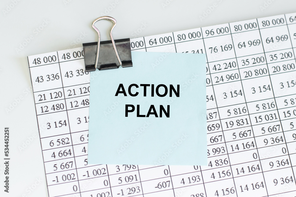 Poster text action plan on a business card on a light table with a document
