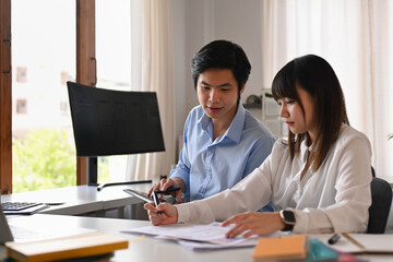 Obraz premium Young creative people collaborating on mobile application software design project at modern co working office