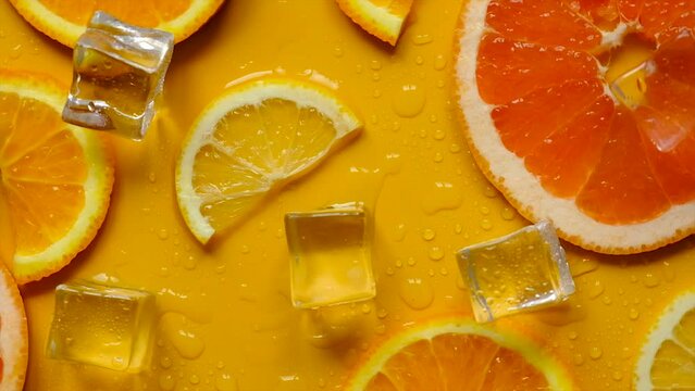 Citruses and ice on a yellow background. Selective focus.