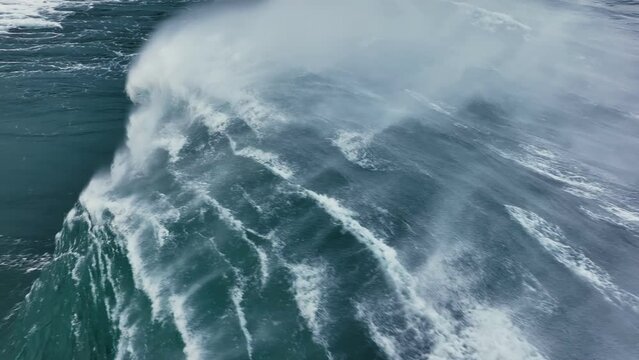 Slow motion aerial shot of powerful wave crashing. Sea or ocean big stormy surf clear turquoise water with foamy white texture. Stormy powerful waves in open Atlantic ocean